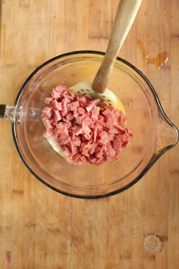 chopped salami and egg in a glass batter bowl