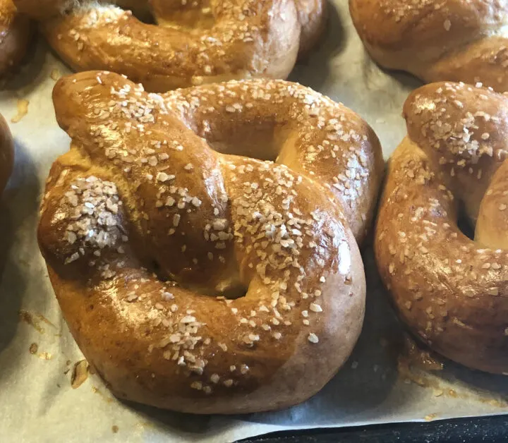 close up of soft sourdough pretzels on a baking sheet