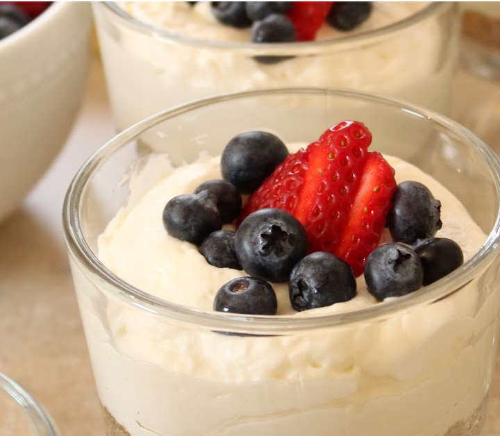 close up of an individual no-bake cheesecake in a mini trifle bowl with fresh berries on top