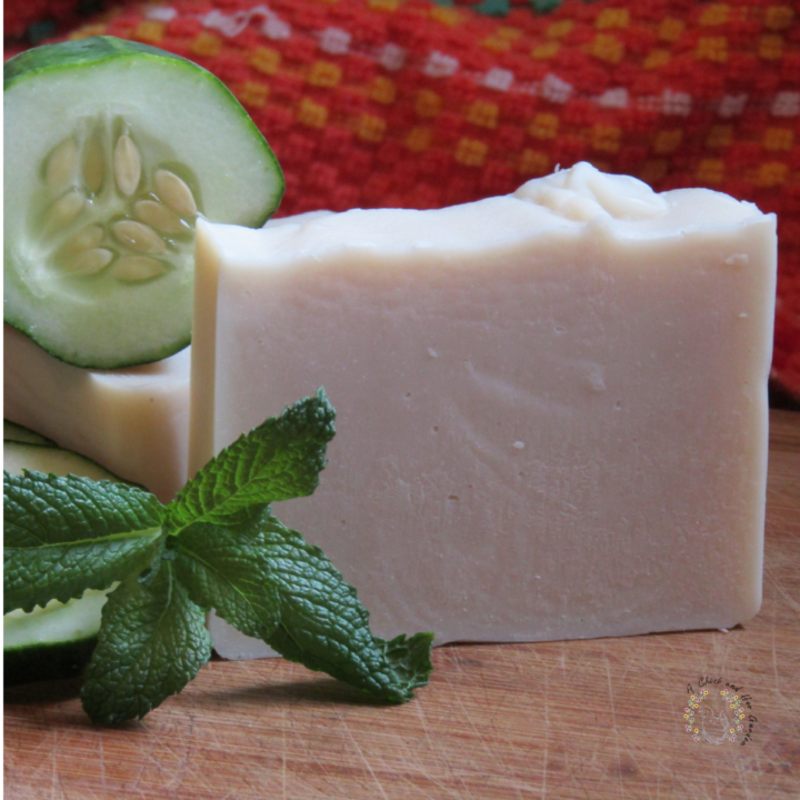 white soap with a sprig of mint and a slice of cucumber