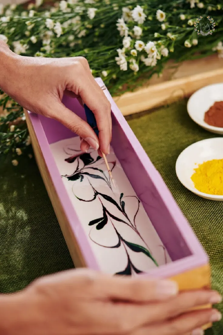 Process of woman making swirl soap in a loaf mold