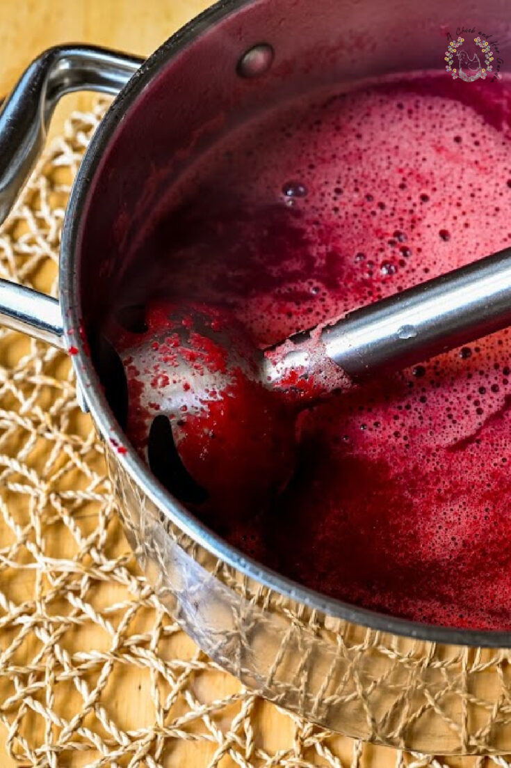 Immersion blender in pot with beetroot soup