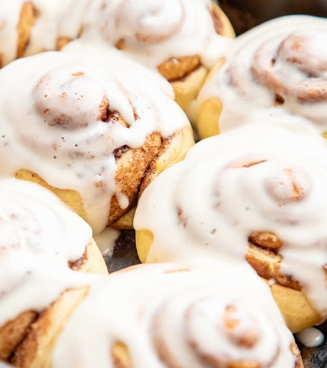 pan of fresh baked cinnamon rolls topped with icing