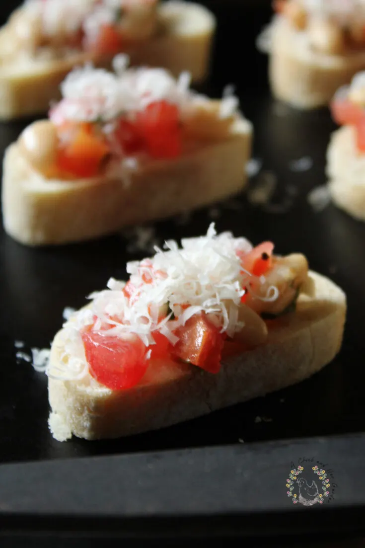 prepared bruschetta on baguette slices on a baking sheet